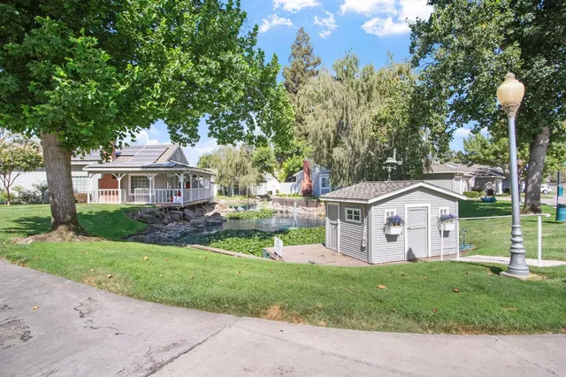 a front view of a house with a garden and trees