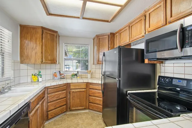 a kitchen with stainless steel appliances a refrigerator sink and microwave