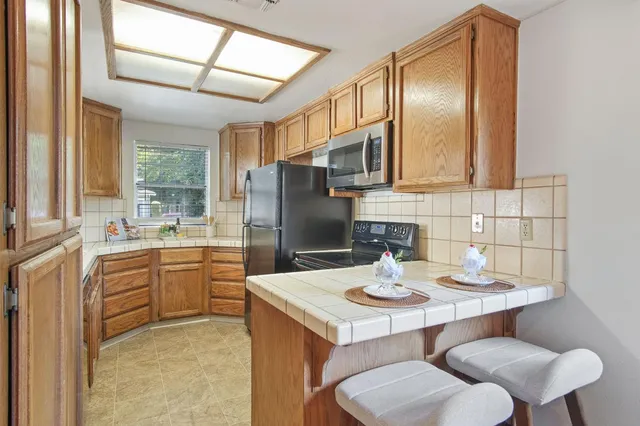 a kitchen with stainless steel appliances a sink and a refrigerator