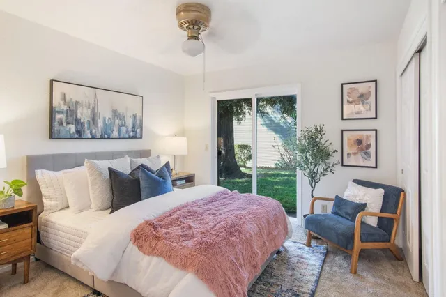 a bedroom with a bed a lamp and a large window