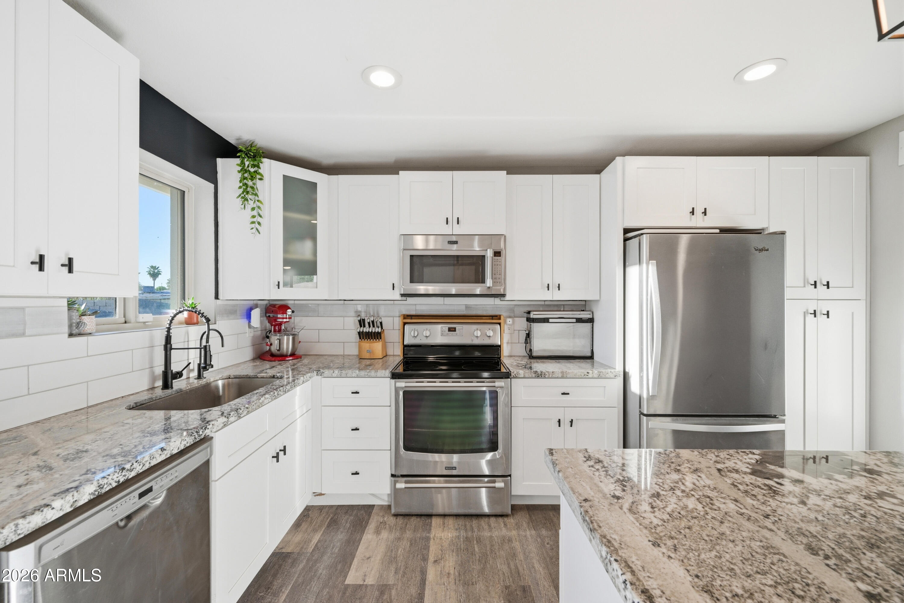 436 North Larkspur Street Gilbert, AZ 85234 - Photo 5 of 31 a kitchen with granite countertop a refrigerator stove and sink