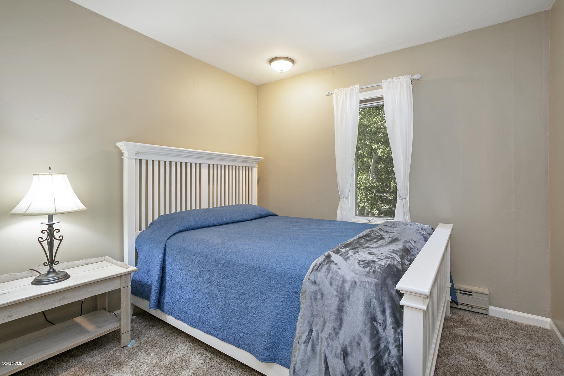 124 Eagle Road, Unit C Avon, CO 81620 - Photo 11 of 35 a bedroom with a bed and a lamp