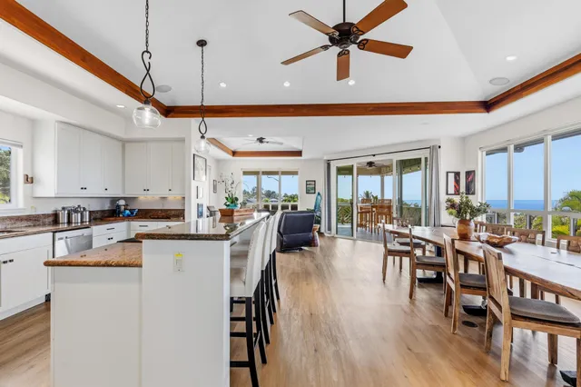 a view of a dining room and livingroom with furniture wooden floor a chandelier