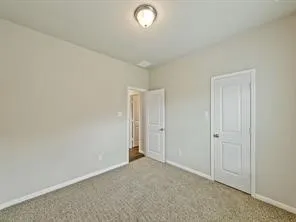 an empty room with closet area and bathroom