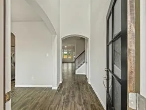 a view of a hallway with wooden floor and staircase