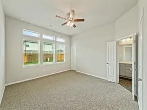 a view of an empty room with a window and a kitchen