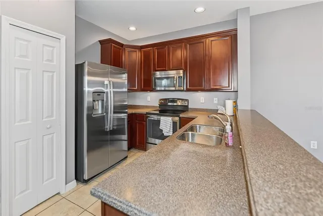 a kitchen with stainless steel appliances granite countertop a sink refrigerator and cabinets