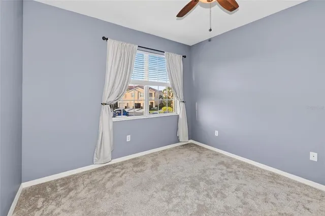 an empty room with fan and windows