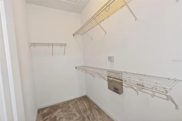 an empty room with windows and chandelier fan