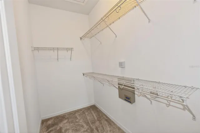 an empty room with windows and chandelier fan