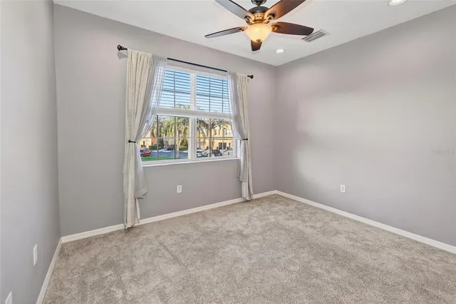 an empty room with windows and fan