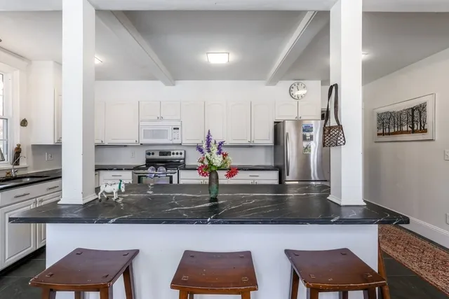 a kitchen with stainless steel appliances granite countertop a sink refrigerator and cabinets