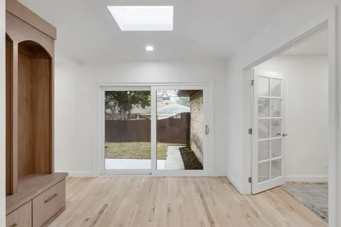a view of livingroom with front door and wooden floor