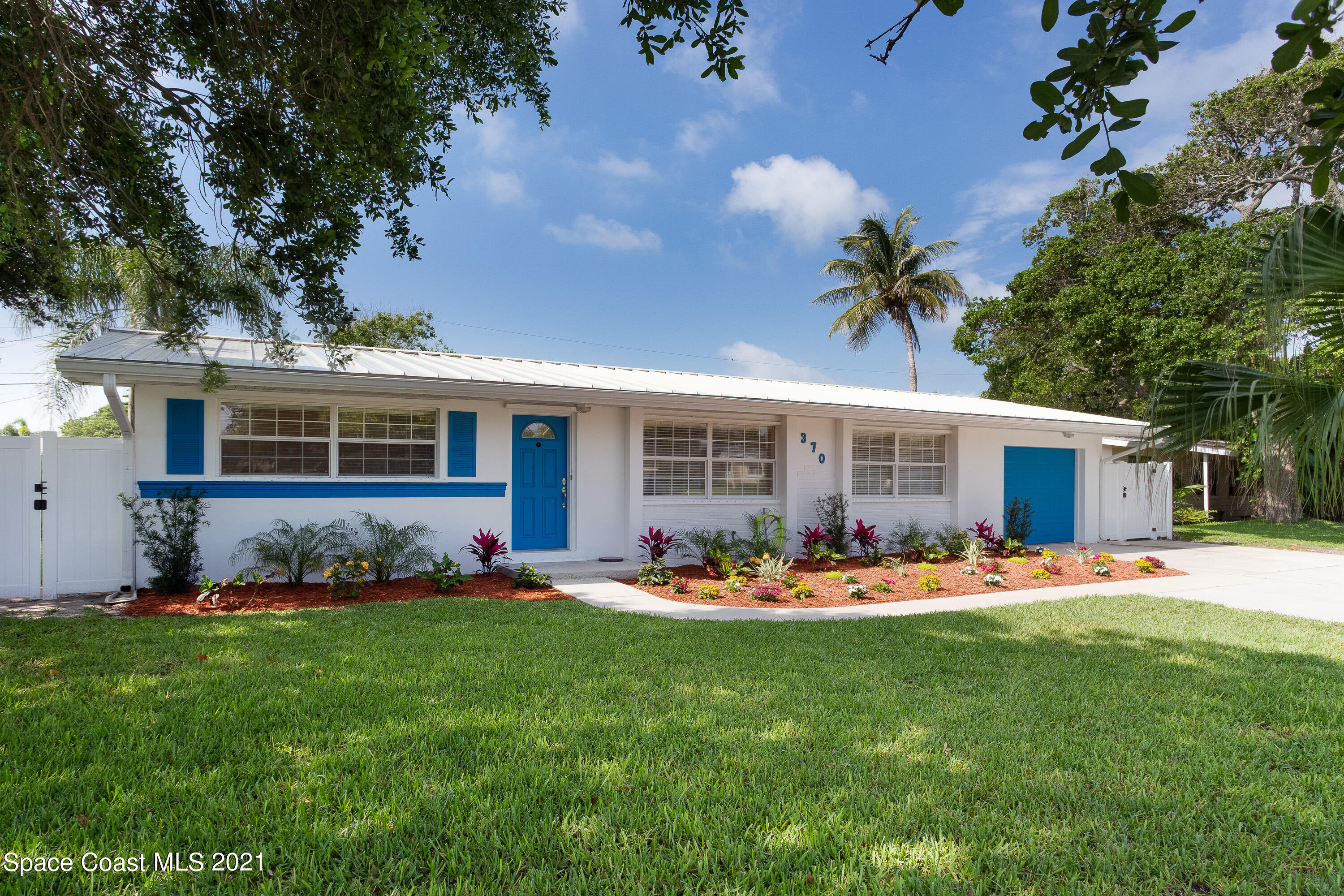 370 Capri Road Cocoa Beach, FL 32931 - Photo 1 of 21 a front view of a house with a garden and patio