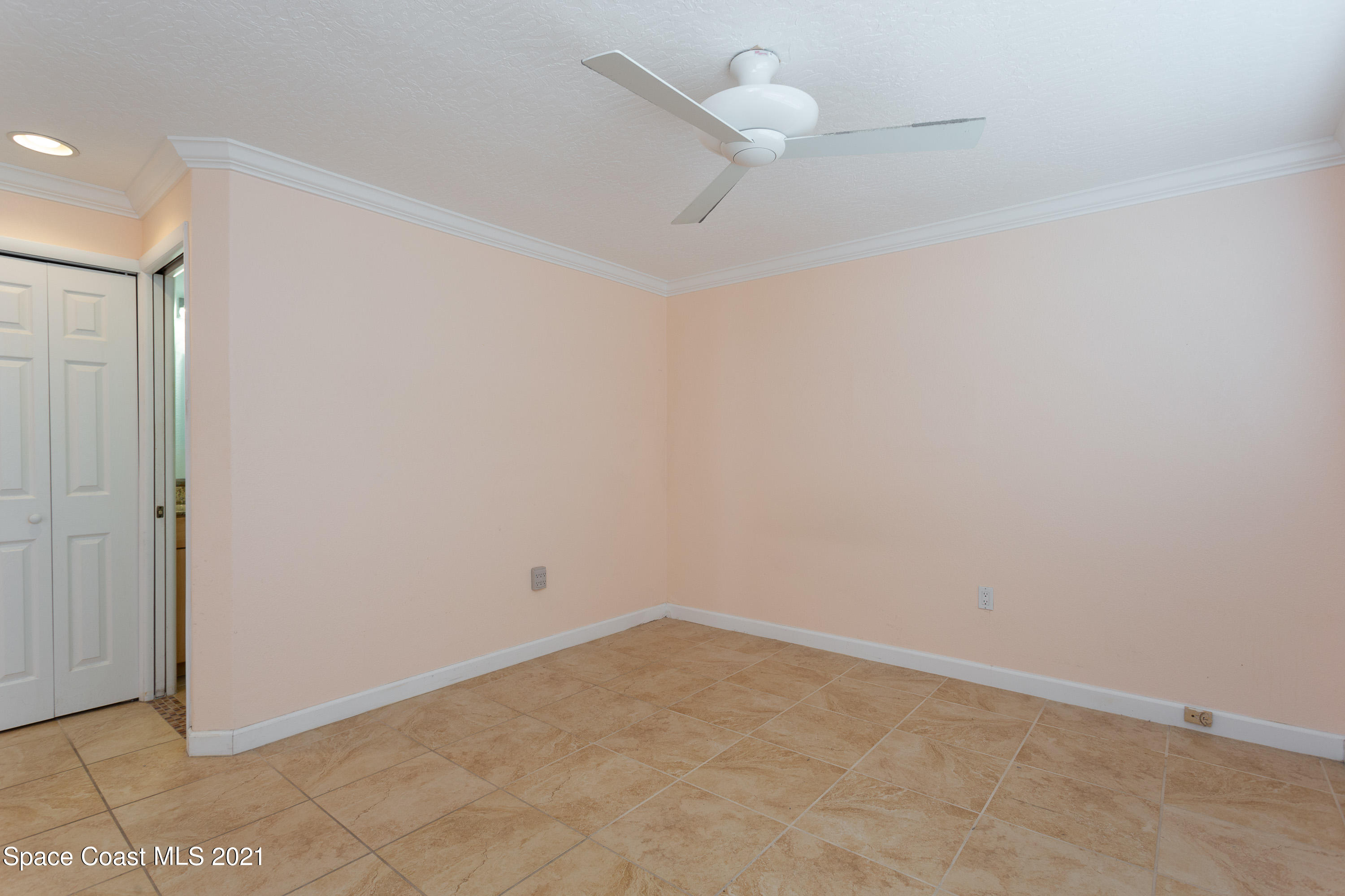 370 Capri Road Cocoa Beach, FL 32931 - Photo 13 of 21 an empty room with a ceiling fan and carpet
