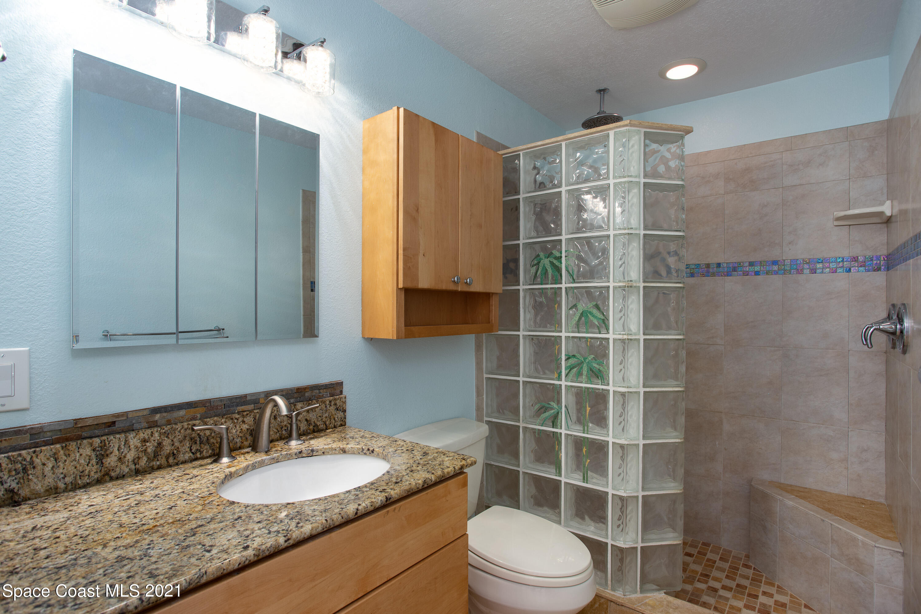 370 Capri Road Cocoa Beach, FL 32931 - Photo 15 of 21 a bathroom with a granite countertop sink toilet a mirror and shower