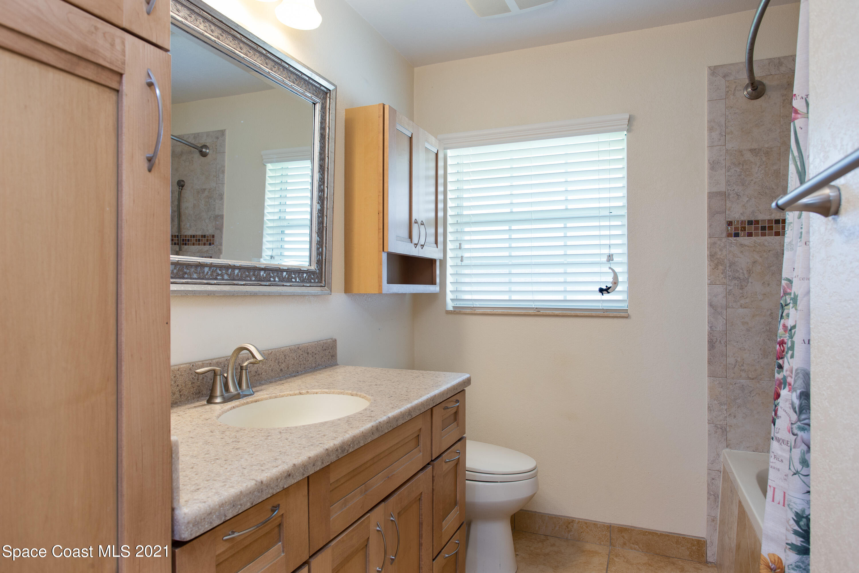 370 Capri Road Cocoa Beach, FL 32931 - Photo 18 of 21 a bathroom with a granite countertop sink toilet and a mirror