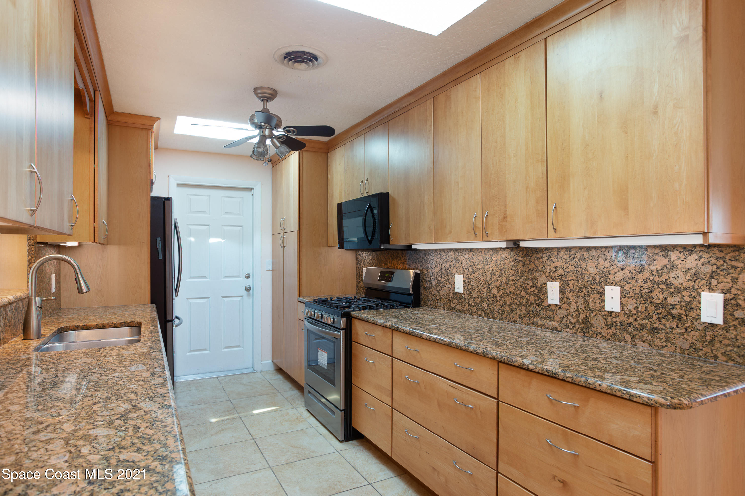 370 Capri Road Cocoa Beach, FL 32931 - Photo 8 of 21 a kitchen with granite countertop a sink stainless steel appliances and cabinets