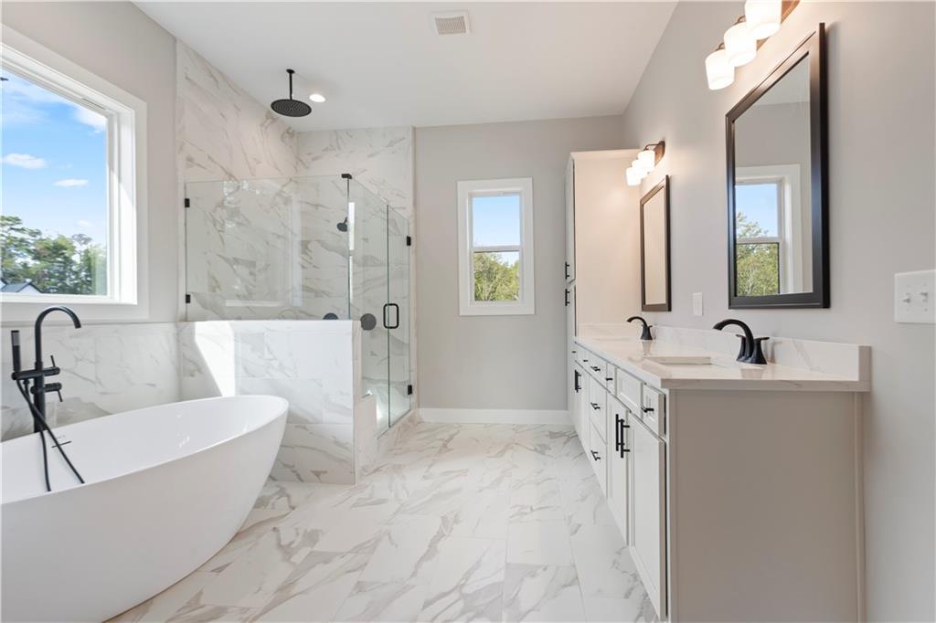 150 Old Sandhill Road Carrollton, GA 30116 - Photo 24 of 36 a bathroom with a tub a sink a mirror and shower