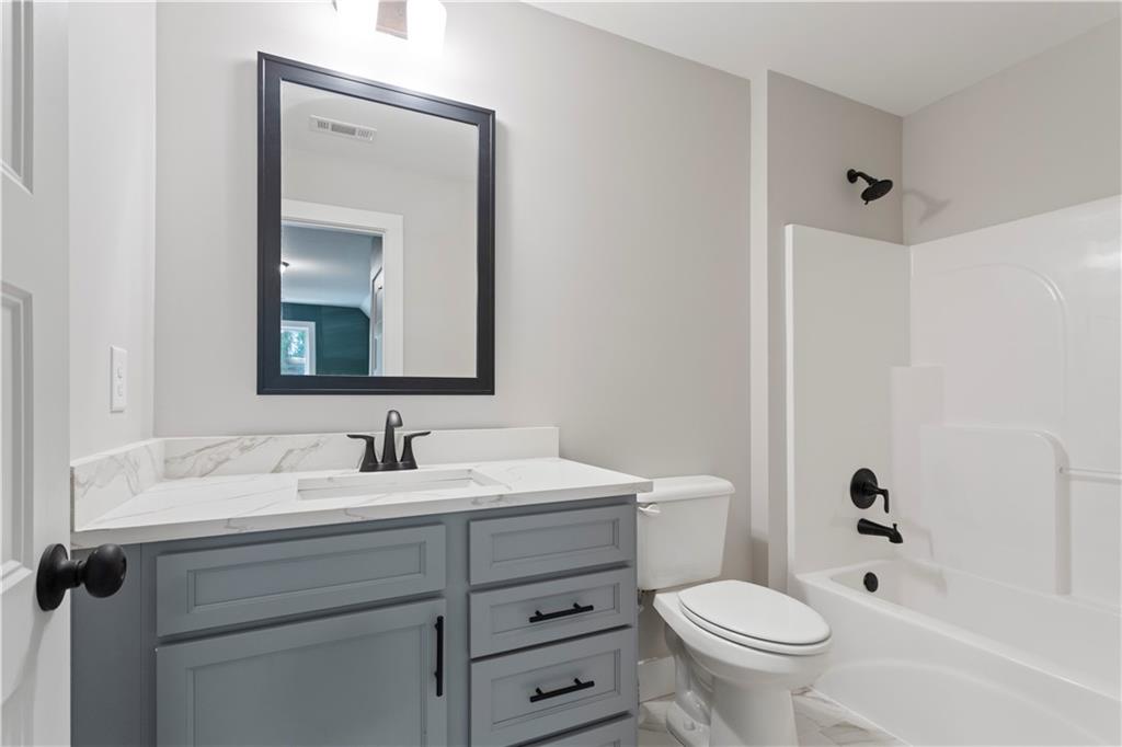 150 Old Sandhill Road Carrollton, GA 30116 - Photo 30 of 36 a bath room with a toilet a sink and a mirror