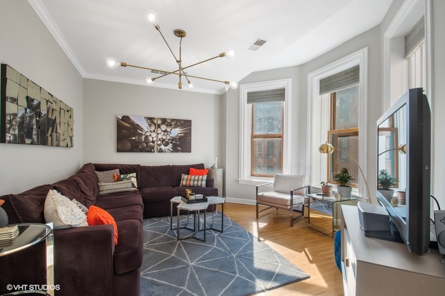 550 West Surf Street, Unit C314 Chicago, IL 60657 - Photo 11 of 21 a living room with furniture a flat screen tv and a large window