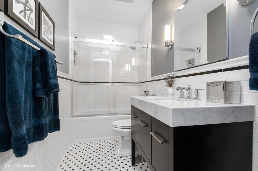 550 West Surf Street, Unit C314 Chicago, IL 60657 - Photo 16 of 21 a bathroom with a sink a toilet a mirror and shower