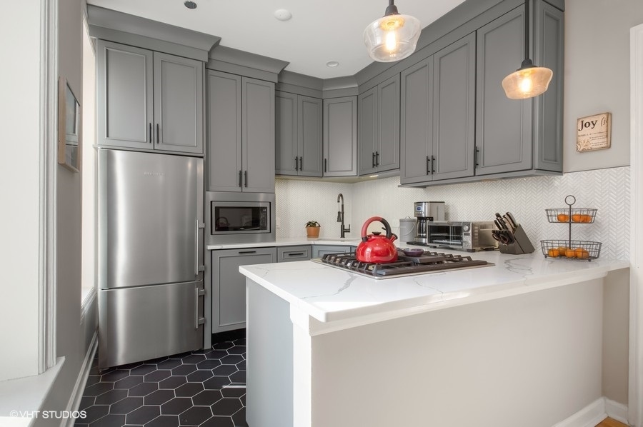 550 West Surf Street, Unit C314 Chicago, IL 60657 - Photo 3 of 21 a kitchen with stainless steel appliances a refrigerator a sink a stove a microwave and cabinets