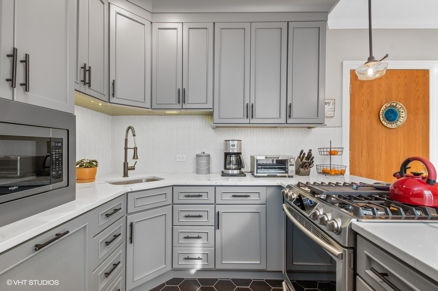 550 West Surf Street, Unit C314 Chicago, IL 60657 - Photo 4 of 21 a kitchen with stainless steel appliances granite countertop a stove a sink dishwasher and cabinets with wooden floor