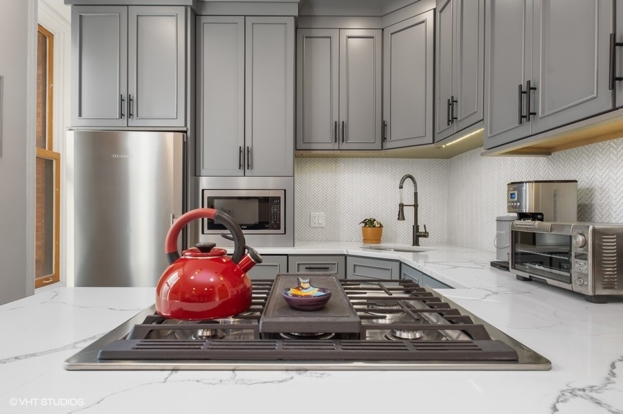 550 West Surf Street, Unit C314 Chicago, IL 60657 - Photo 5 of 21 a kitchen with stainless steel appliances granite countertop a refrigerator stove and white cabinets