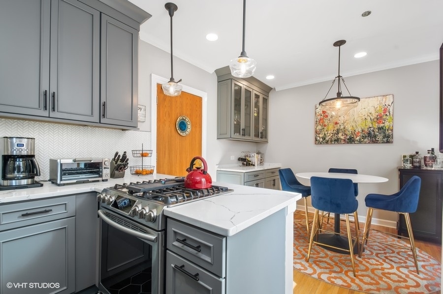 550 West Surf Street, Unit C314 Chicago, IL 60657 - Photo 6 of 21 a kitchen with stainless steel appliances granite countertop a stove a sink dishwasher and white cabinets with wooden floor