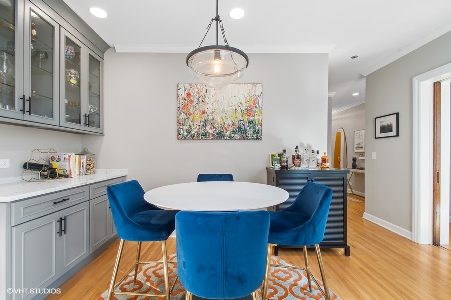 550 West Surf Street, Unit C314 Chicago, IL 60657 - Photo 7 of 21 a view of a dining room with furniture wooden floor and a chandelier