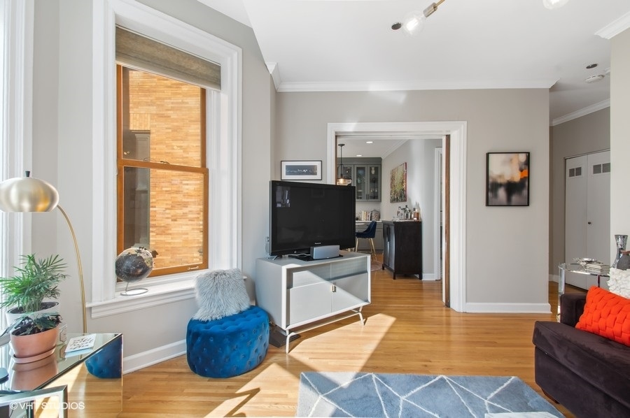 550 West Surf Street, Unit C314 Chicago, IL 60657 - Photo 9 of 21 a living room with furniture and a flat screen tv