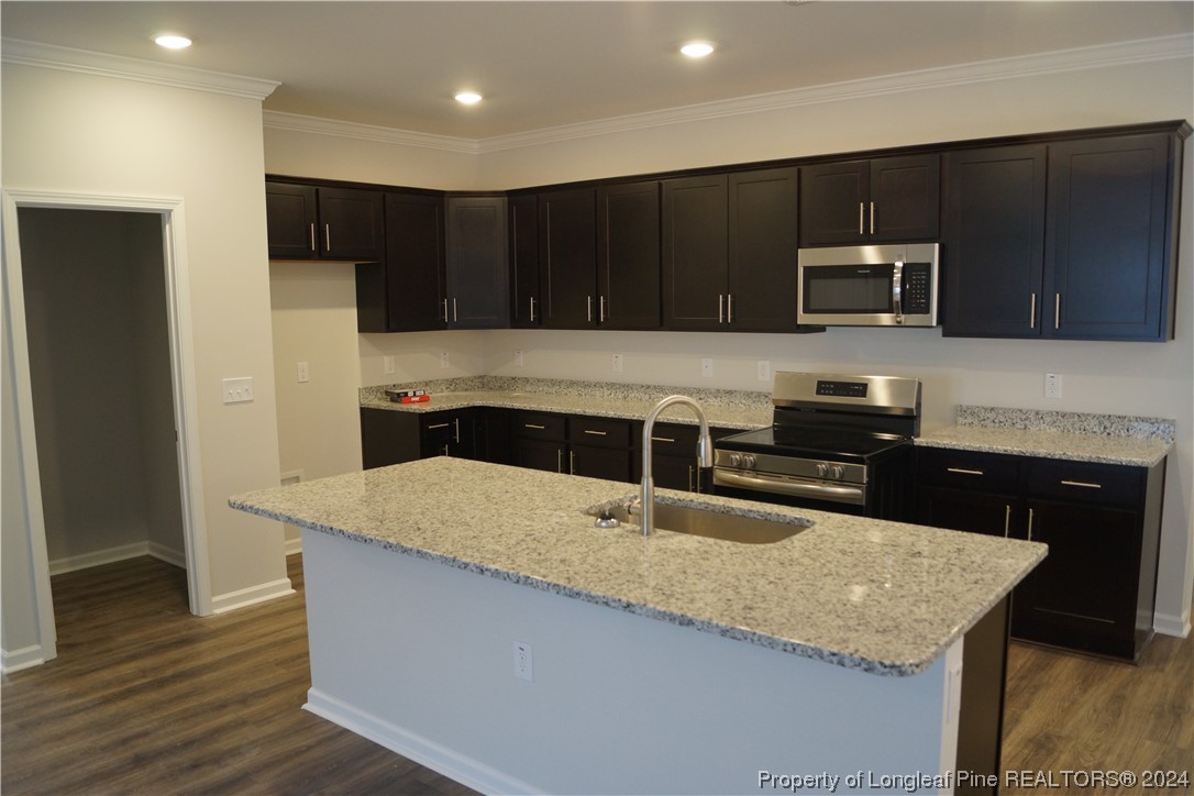111 Knotts Berry Road Bunnlevel, NC 28323 - Photo 13 of 32 a kitchen with stainless steel appliances wooden cabinets and granite counter tops