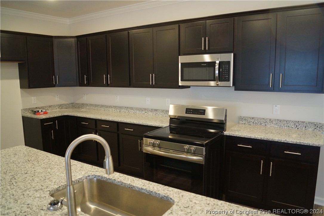 111 Knotts Berry Road Bunnlevel, NC 28323 - Photo 15 of 32 a kitchen with granite countertop a stove and a microwave