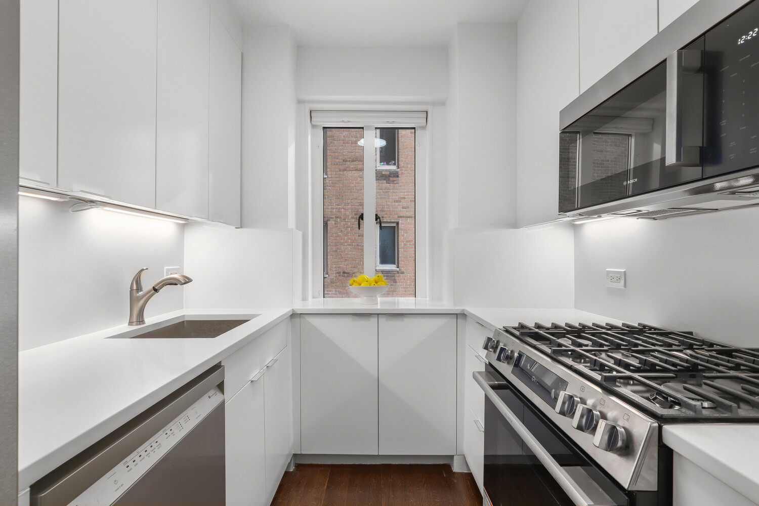 135 East 71st Street, Unit 3D Manhattan, NY 10021 - Photo 5 of 11 a kitchen with granite countertop stainless steel appliances a sink stove and cabinets