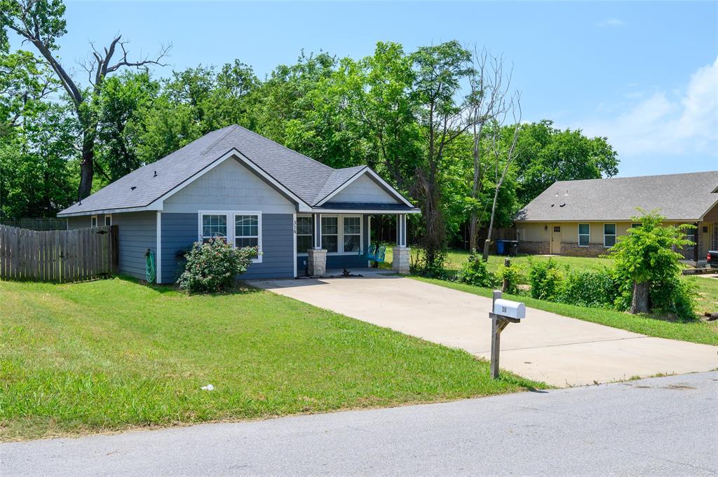 318 Munson Street Denison, TX 75021 - Photo 2 of 21 a front view of a house with a yard and garage