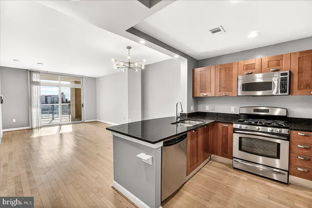 a kitchen with stainless steel appliances granite countertop a stove a sink and a microwave