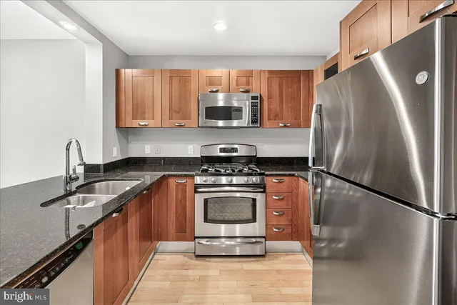 a kitchen with stainless steel appliances granite countertop a sink stove and refrigerator