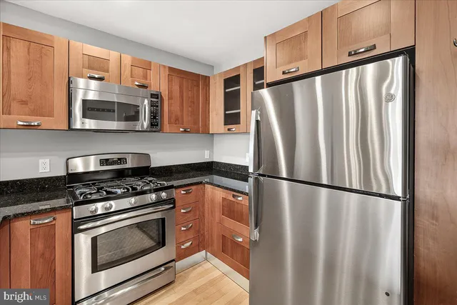 a kitchen with stainless steel appliances granite countertop a refrigerator stove and microwave
