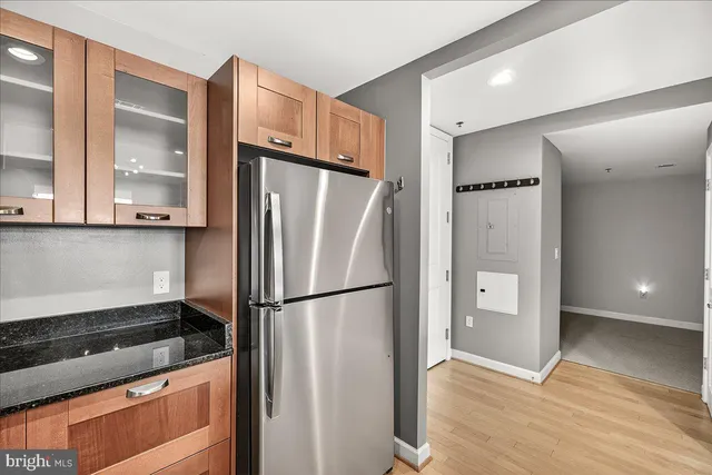 a kitchen with stainless steel appliances granite countertop a refrigerator and a stove top oven