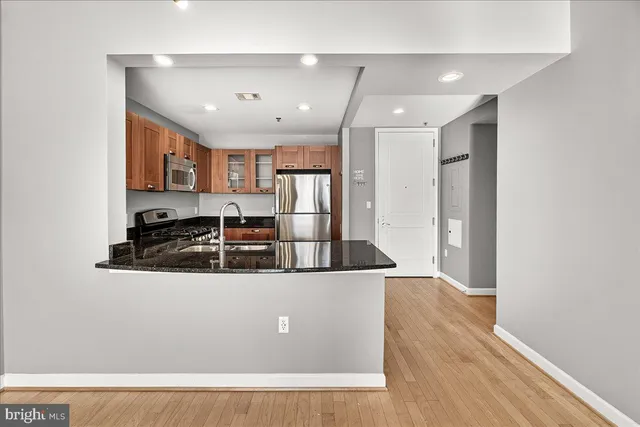a view of a kitchen with stainless steel appliances granite countertop a stove and a refrigerator