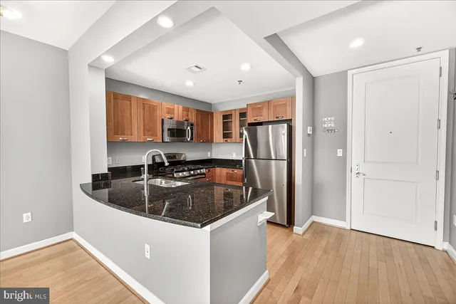 a kitchen with stainless steel appliances granite countertop a sink a stove and a refrigerator