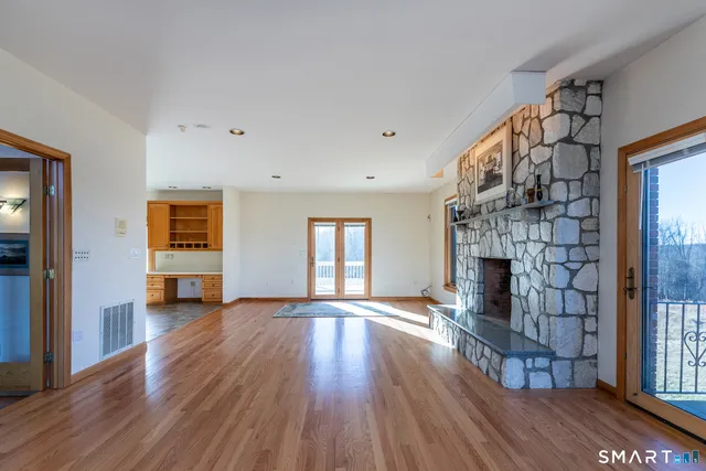 an empty room with wooden floor and fireplace