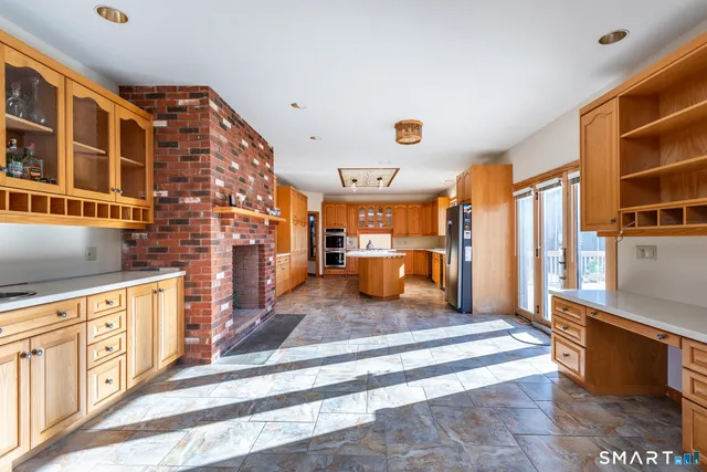 a living room with stainless steel appliances furniture a rug and a large window