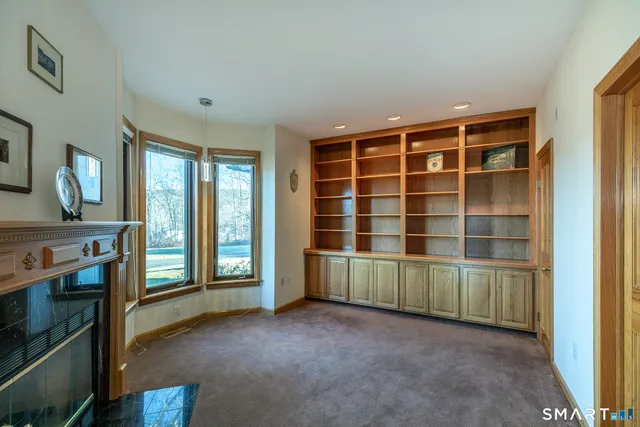 a view of an empty room with a fireplace and a window