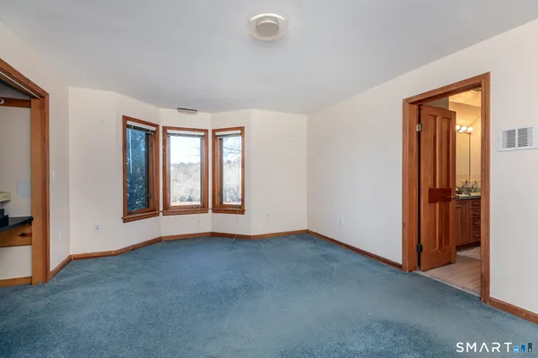 a living room with stainless steel appliances furniture a rug and a large window