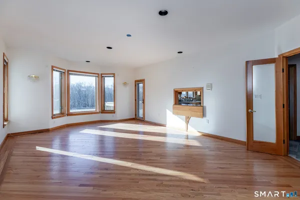 a view of an empty room with window and fire place