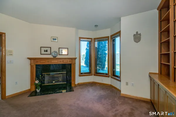 a view of an empty room with a fireplace and a window