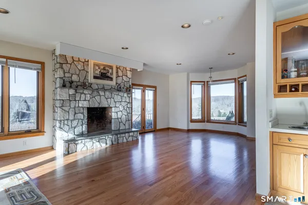 a view of empty room with wooden floor and fireplace