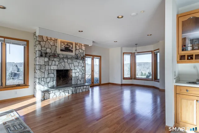 a view of empty room with wooden floor and fireplace